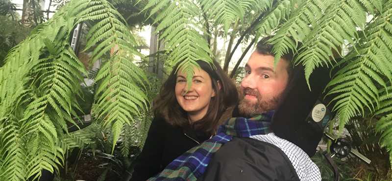 A photograph of Kiki and Euan in the Botanic Gardens at Kingsbarnes with plants all around them.